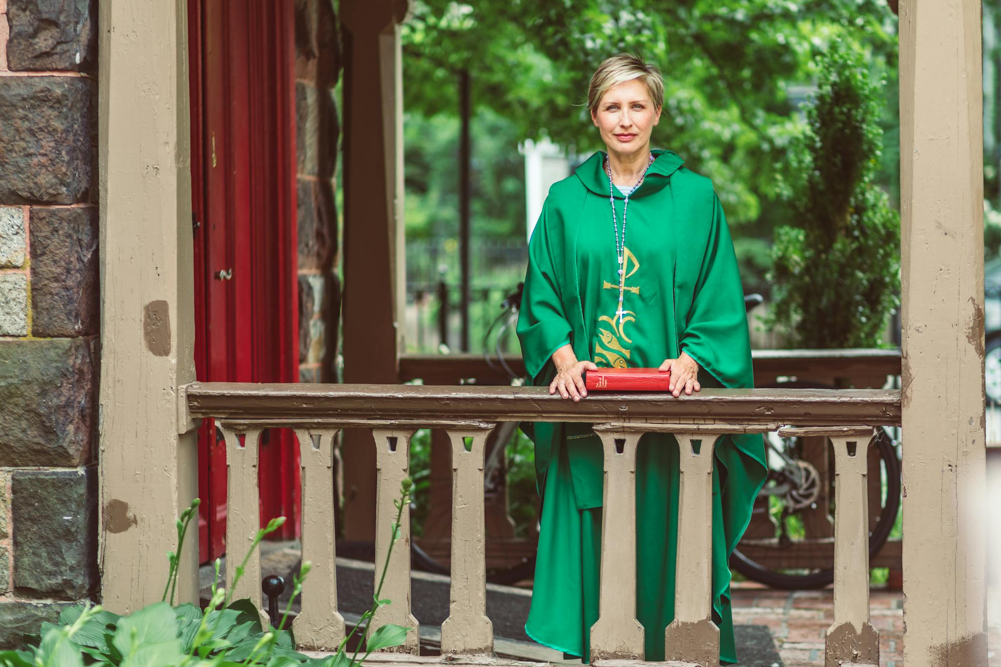 Woman In Green Chasuble Holding A Bible